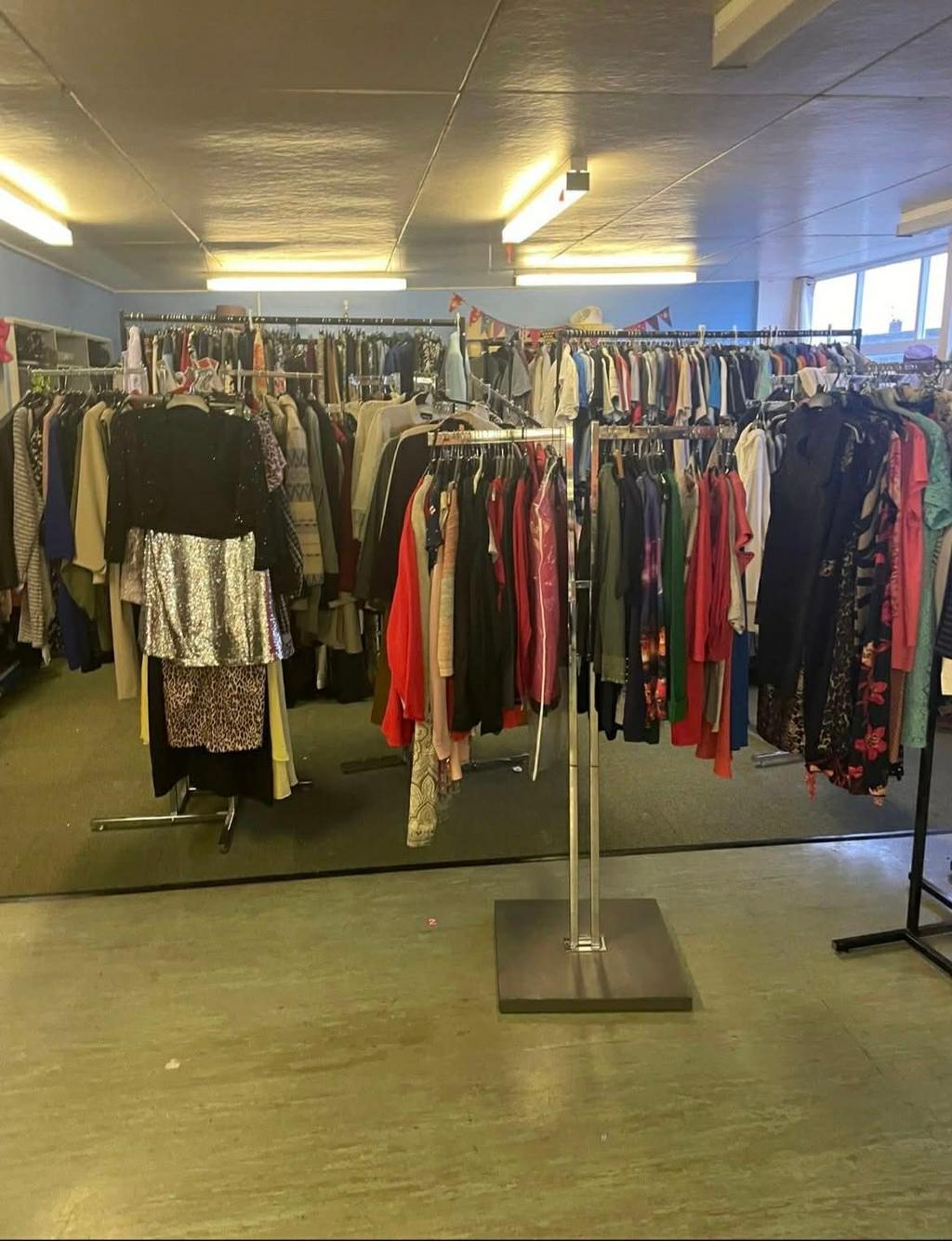 Clothing rails in the charity shop with a wide range of second-hand garments